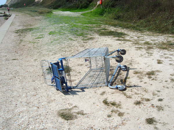 A supermarket trolley at the base of the cliffs