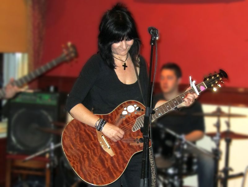 Jo with a clamp on her guitar fretboard