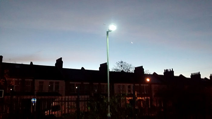 a thin crescent moon
                  outshone by a lamp