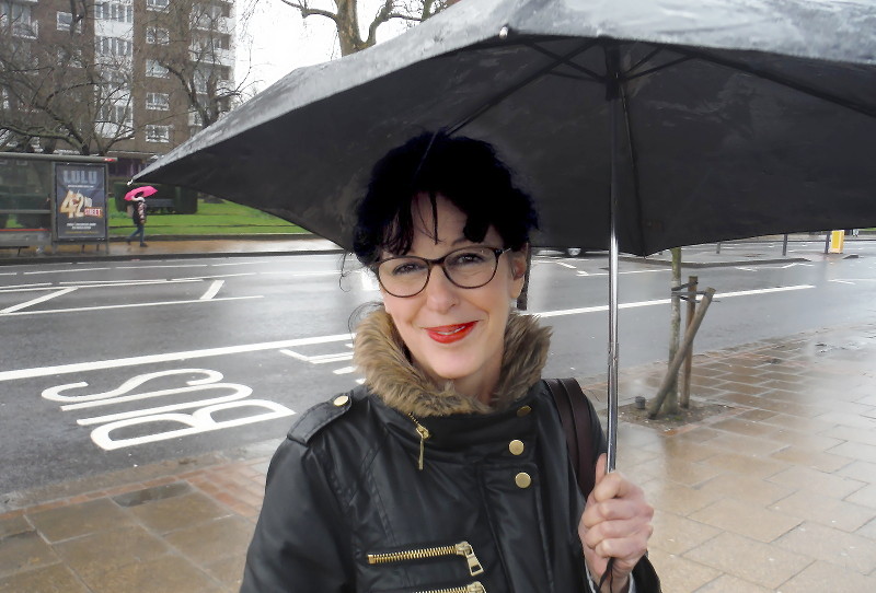 Angela under her umbrella in the
                              rain