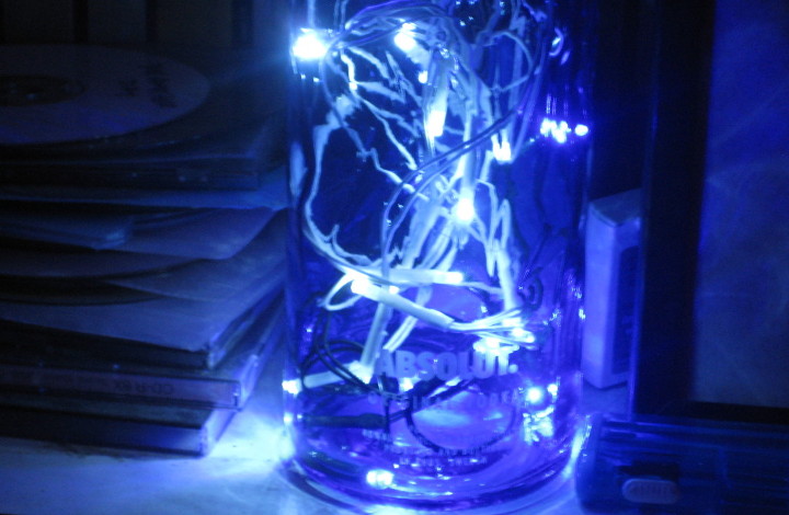 blue and white lights
                        in a blue Absolut bottle